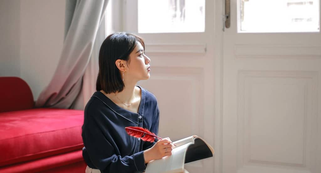 Seorang wanita yang sedang melakukan refleksi diri dengan cara journaling.