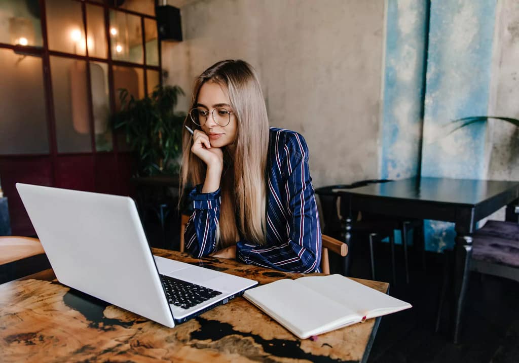 Seseorang di depan laptop sedang menyusun skala prioritas