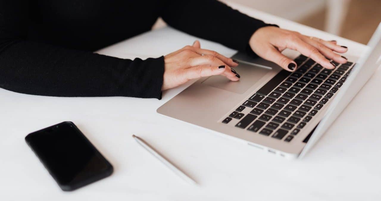Seorang wanita yang sedang produktif dengan mengetik di laptop.